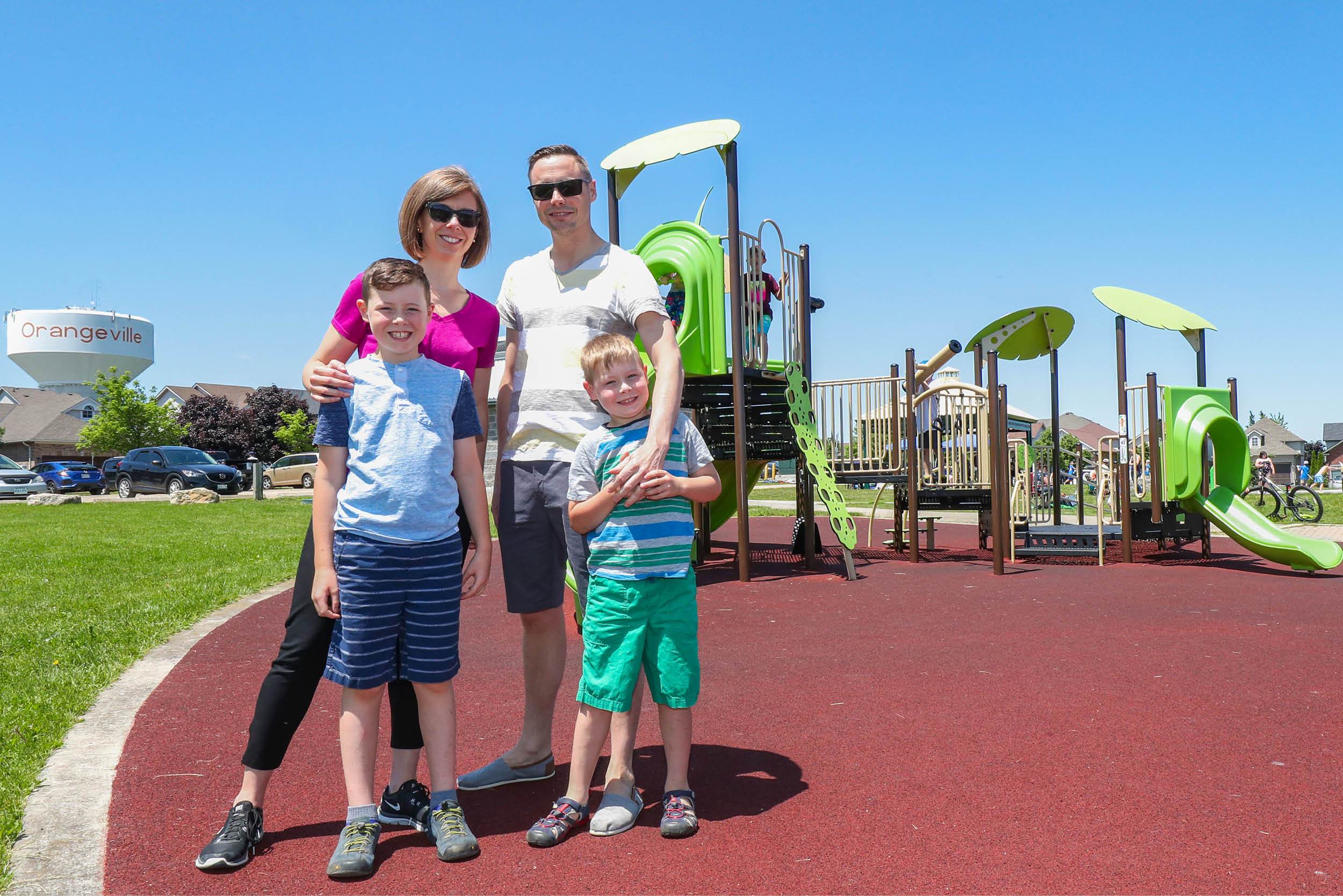 Family of four standing in playground